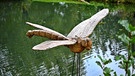 Hier war ein Künstler am Werk. Libelle am Teich geschnitzt aus Holz. Gesehen im Freilandmuseum Fladungen in der Rhön. | Bild: Horst Bertzky, Bad Kissingen, 04.10.2024