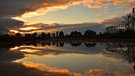 In Richtung Obermichelbach diente eine große Wasserpfütze für ein malerisches Spiegelbild mit einem schönen Sonnenuntergang darin. | Bild: Wilfried Wagner, Erlangen, 07.10.2024