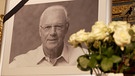 Schwarz-weiß Bild von Franz Beckenbauern hinter weißen Rosen | Bild: Bayerischer Rundfunk 2024