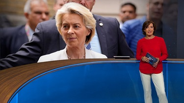 BR24-Moderatorin Ursula Heller neben einem Bild von Ursula von der Leyen | Bild: Bayerischer Rundfunk 2024