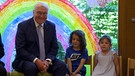 Frank-Walter Steinmeier sitzt neben zwei Kindern | Bild: Bayerischer Rundfunk 2024