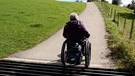 Frau im Rollstuhl auf Bergweg | Bild: Bayerischer Rundfunk 2024