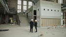 Zwei Männer stehen im Innenraum der Bergson-Baustelle | Bild: Bayerischer Rundfunk 2023