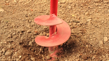 Ein Bohrer gräbt ein Loch ins Erdreich. | Bild: colourbox.com
