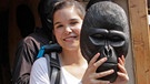 Anna mit einer geschnitzten Gorilla-Maske in der Hand. | Bild: BR, Text und Bild Medienproduktion GmbH & Co. KG