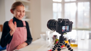 gestellte Szene: Ein Mädchen arbeitet als Influencerin und filmt sich mit einer Kamera beim Frühstück. | Bild: colourbox.com