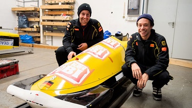 Der Schlitten-Check | Checker Tobi (rechts) saust gemeinsam mit dem Profi-Bobfahrer Max Illmann im Bob durch den Eiskanal. | Bild: BR | megaherz gmbh | Hans-Florian Hopfner