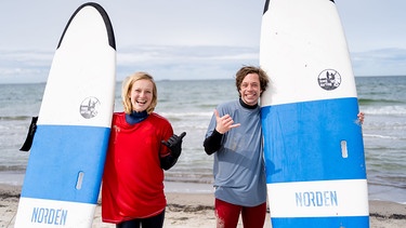 Der Wellen-Check / Wie der Checker eine perfekte Welle reitet, das zeigt ihm Surflehrerin Fiona am Meer.  | Bild: BR/megaherz gmbh/Hans-Florian Hopfner