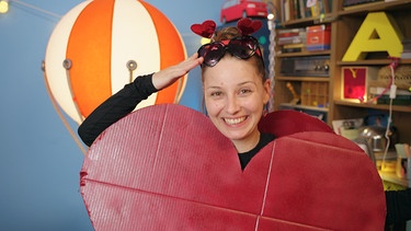 Der Herz-Check | Checkerin Marina findet heraus, was es mit dem berühmten roten Herzsymbol auf sich hat.  | Bild: BR | megaherz gmbh | Amelie Cran