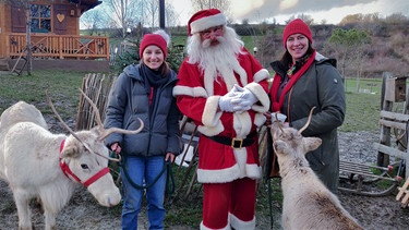 Der Weihnachts-Check | Checkerin Marina mit dem Weihnachtsmann und seinen Rentieren. Naja, also eigentlich gehören diese hier Sonja. Sie betreibt eine Rentieralm. | Bild: BR | megaherz gmbh | Miriam Bade