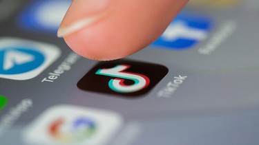 Ein Finger tippt das TikTok-Symbol af dem Smartphone-Display an. | Bild: BR/Vera Johannsen