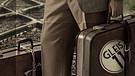 Junger Südländer mit altem Koffer vor Zuggleisen | Bild: colourbox.com; Montage: BR/Tanja Begovic