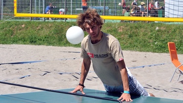 Junger Mann spielt Headis, eine neue Art des Tischtennisspielens mit dem Kopf | Bild: picture-alliance/dpa