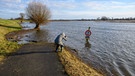 Eine Frau fotografiert im Überschwemmungsgebiet (Symbolbild) | Bild: picture alliance / PIC ONE | Stefan Müller