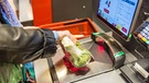 Eine Kundin führt verpackten Brokkoli über einen Scanner an einer Selbstbedienungskasse in einem Lebensmittelsupermarkt. | Bild: picture alliance/dpa | Frank Hammerschmidt