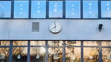 Die Schuluhr an der Fassade einer Grundschule zeigt kurz vor 8 Uhr am Morgen (Symbolbild) | Bild: pa/dpa/Annette Riedl