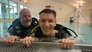 Julian Reger mit seinem ehrenamtlichen Tauchlehrer Manfred van Appeldorn im Schwimmbad der Pfennigparade in München.  | Bild: BR/ Elisabeth Tyroller 