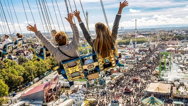 Bei Sonnenschein und strahlend blauem Himmel drehen Wiesnbesucher eine letzte Runde über der Festwiese | Bild: picture alliance / Wolfgang Maria Weber | Wolfgang Maria Weber