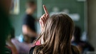 Schülerinnen und Schüler einer vierten Klasse einer Grundschule nehmen am Unterricht teil, eine Schülerin meldet sich.  | Bild: dpa-Bildfunk/Marijan Murat