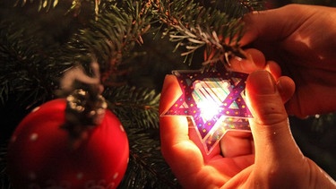 "Weihnukka"-Tannenbaum mit jüdischem Weihnachtsschmuck. Bereits im ausgehenden 19. Jahrhundert hat es nach Aussage der Leiterin des Jüdischen Museums Berlin Familien gegeben, die Weihnachten und Chanukka feierten.  | Bild: picture alliance / dpa | Bodo Marks