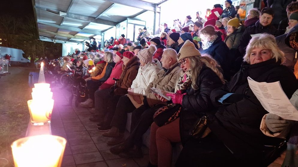 Viele Menschen haben am ersten Stadionsingen in Augsburg teilgenommen. | Bild: BR/Til Antonie Wiesbeck