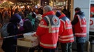  Ehrenamtliche Mitglieder des Deutschen Roten Kreuzes (DRK) verteilen Lebensmittel an obdachlose Menschen. | Bild: picture alliance/dpa | Georg Wendt