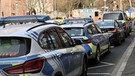 Einige Polizeifahrzeuge und Rettungswagen stehen in der Nähe eines Tatortes in Aschaffenburg | Bild: Ralf Hettler/dpa +++ dpa-Bildfunk +++