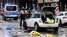 Ein Polizist fotografiert ein Auto am Einsatzort. In der Münchner Innenstadt ist ein Fahrzeug in eine Menschengruppe gefahren. | Bild: picture alliance/dpa | Matthias Balk