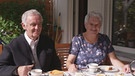 Marita Großmann und Pfarrer Josef Schranner beim Kaffeetrinken.  | Bild: BR