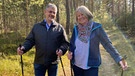 Gut für Körper, Geist und Seele: Gis Belmann-Bucka mit ihrem Mann Thomas beim Nordic Walking im Wald.  | Bild: BR