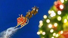 Ein Weihnachtsmann fliegt mit seinem Rentierschlitten über einen Christkindlmarkt. | Bild: picture alliance / Geisler-Fotopress | Dwi Anoraganingrum/Geisler-Fotop