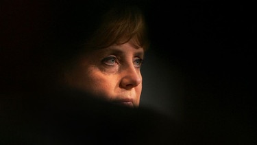 Das Gesicht der Ex-Kanzlerin Angela Merkel ist zum Teil von Schatten verdeckt | Bild: picture-alliance/ dpa/dpaweb | Rolf Vennenbernd