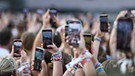 Fans halten während der Show von Taylor Swift im Münchner Olympiastadion Smartphones in die Luft. | Bild: picture alliance / SZ Photo | Leonhard Simon