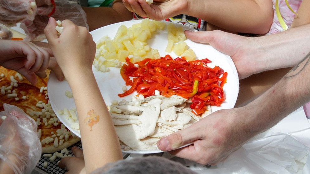 Kinder aus der Ukraine belegen gemeinsam eine Pizza (Symbolbild) | Bild: picture alliance/Mykola Miakshykov / Avalon