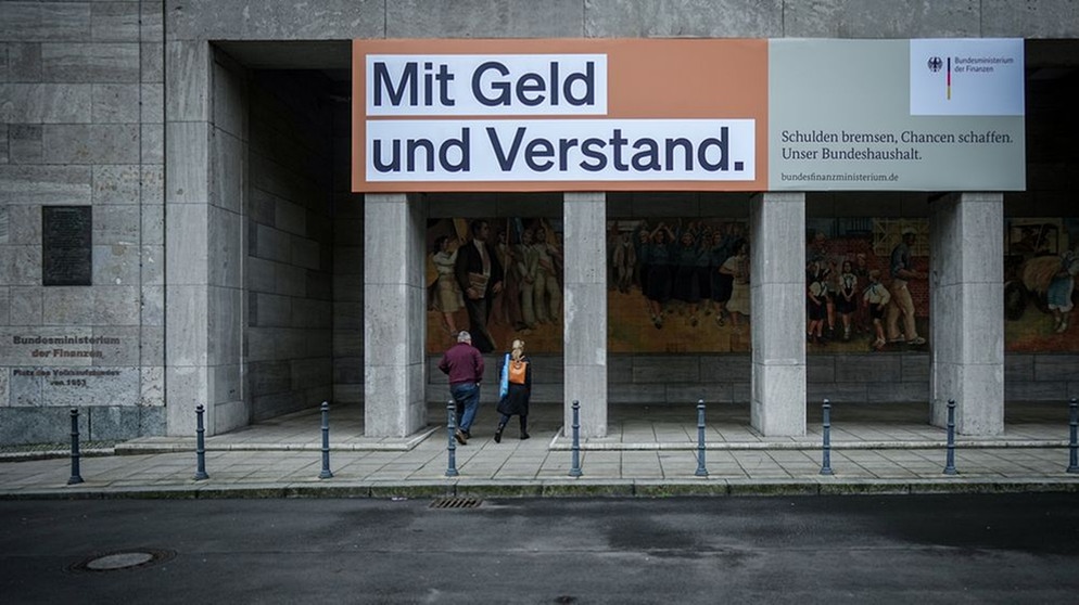 Ein Plakat mit der Aufschrift "Mit Geld und Verstand. Schulden bremsen, Chancen schaffen. Unser Bundeshaushalt." hängt über dem Eingang zum Bundesministerium der Finanzen in Berlin. | Bild: dpa-Bildfunk/Kay Nietfeld