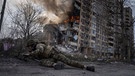 Ukraine, Awdijiwka: Dieses von AP am 21.03.2023 zur Verfügung gestellte Foto zeigt einen ukrainischen Polizisten vor einem brennenden Gebäude. | Bild: dpa-Bildfunk/Evgeniy Maloletka