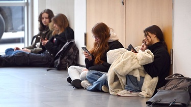 Symbolbild: Jugendliche sitzen am Boden und schauen auf ihre Handys  | Bild: picture alliance / SvenSimon | Frank Hoermann/SVEN SIMON