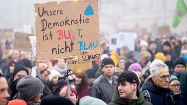 01.02.2025, Niedersachsen, Oldenburg: Zahlreiche Menschen nehmen bei dichtem Nebel mit Plakaten an einer Demonstration gegen rechte Parteien und die gemeinsame Abstimmung von Union und AfD für eine schärfere Migrationspolitik auf dem Schlossplatz teil. | Bild: picture alliance / Hauke-Christian Dittrich | Hauke-Christian Dittrich