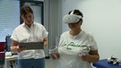 Eine Patientin mit einer VR-Brille (rechts) steht neben einer Frau im Uniklinikum Erlangen | Bild: BR