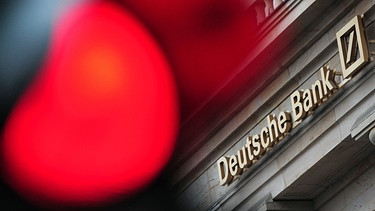 Symbolbild: Eine rote Ampel leuchtet vor einer Filiale der Deutschen Bank | Bild: picture-alliance/dpa/Daniel Reinhardt