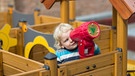 Der zweijährige Tamino schaut am 14.09.2015 in Frankfurt am Main im Garten der Kindertagesstätte "dOSTluk" durch ein Kinder-Fernrohr. | Bild: picture-alliance/dpa