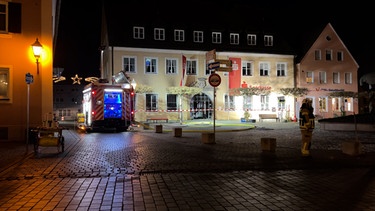 Ein Feuerwehrfahrzeug vor der Sparkassenfiliale am Marktplatz in Herrieden | Bild: BR24