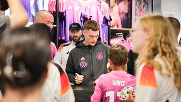 Deutschlands Florian Wirtz (M) gibt bei einer offiziellen Autogrammstunde von Adidas Autogramme. | Bild: dpa-Bildfunk/Christian Charisius