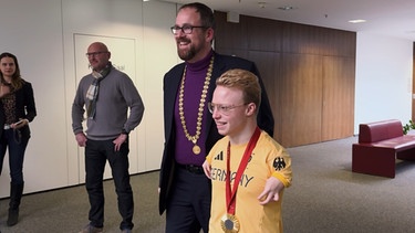 Para-Schwimmer Josia Topf und Oberbürgermeister Florian Janik beim Eintrag ins Goldene Buch der Stadt Erlangen. | Bild: BR