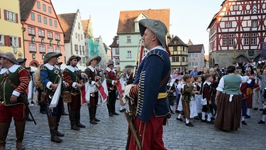 Für den Meistertrunk verkleidete Menschen auf dem Rothenburger Marktplatz. | Bild: BR24/Annalena Sippl