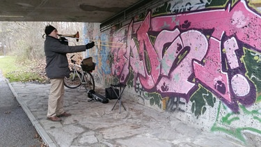 Der Posaunist an der Isar unter der Brücke am Tucherpark. | Bild: BR/David Friedman