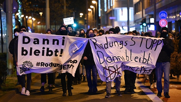 ARCHIV - 20.11.2020, Hessen, Frankfurt/Main: Teilnehmer einer Demonstration gegen den Ausbau der A49 halten in der Frankfurter Innenstadt während eines Demonstrationszuges Plakate mit der Aufschrift "Dani bleibt" und "Rodungsstopp Danni bleibt". Die Demonstration richtet sich gegen die Rodung des Dannenröder Forsts. Das alles trägt die Fraktion der Grünen mit, da sie in Hessen regiert. | Bild: dpa-Bildfunk/Arne Dedert