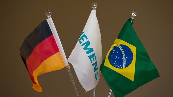 Siemens zeigt sich in Brasilien selbst an: Fahnen von Deutschland, Siemens und Brasilien | Bild: picture-alliance/dpa