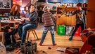 Im Wohnzimmer der Familie Steindl. Die Kinder Lisa (Adele Wolf), Fabian (Friedrich Wolf) und Jakob (Atreju Hollweg, links) spielen mit neuen Spielzeugen, ihr Vater Stefan (Thomas Mraz) findet es nicht gut, dass sie noch mehr Spielsachen bekommen haben und möchte nicht, dass sie mit Schwertern spielen, ihre Mutter Marion (Marleen Lohse) sieht dies entspannter. | Bild: BR/E&A Film/ORF/Stefanie Leo