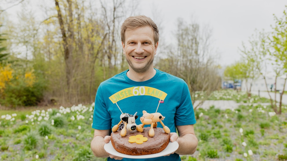 Florian Kienast mit der Jubiläumstorte. | Bild: BR/Leah Tanzer